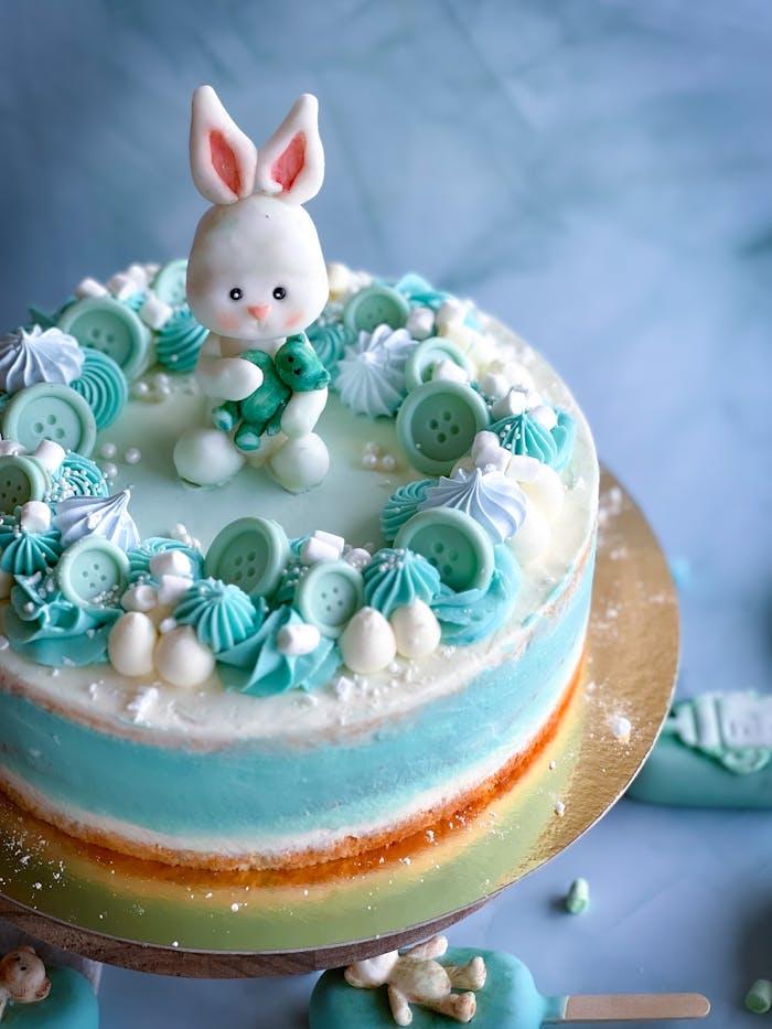 Adorable blue cake with fondant bunny topper, perfect for baby showers or birthdays.