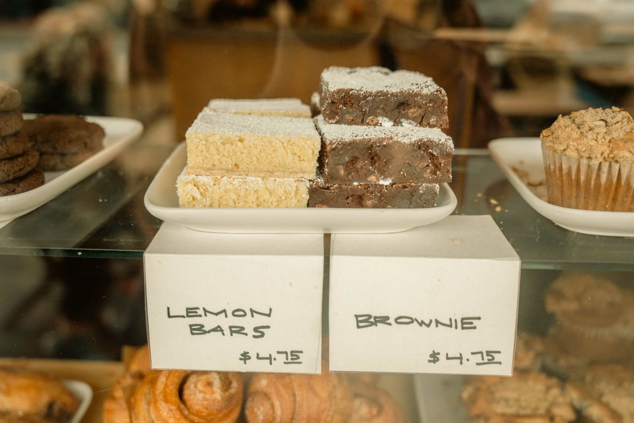 Delicious display of lemon bars and brownies in a bakery with price tags.