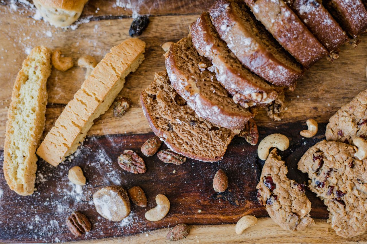 A variety of baked goods and nuts displayed on a rustic wooden board, ideal for food lovers.